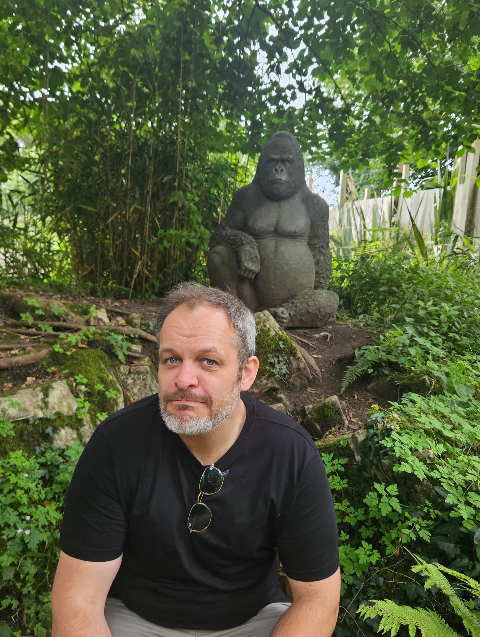 Zane Sturt, local handyman, posing in front of a gorilla statue